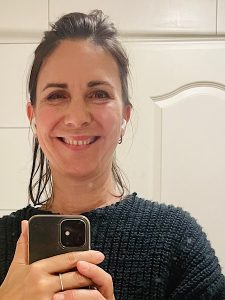 eine Frau lacht in den Spiegel beim Selfie machen